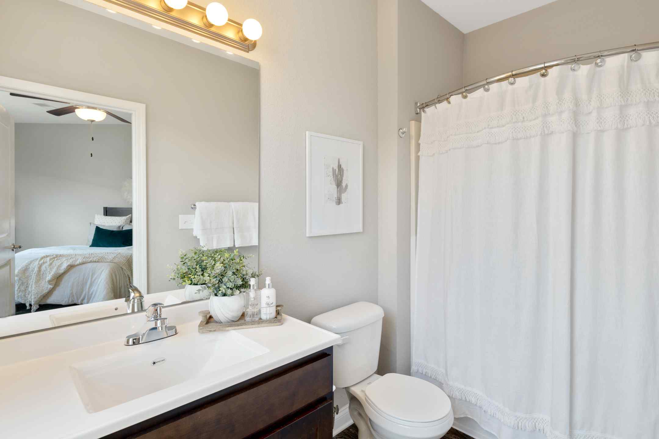 A tidy student housing apartment bathroom with a sink, toilet and bath.