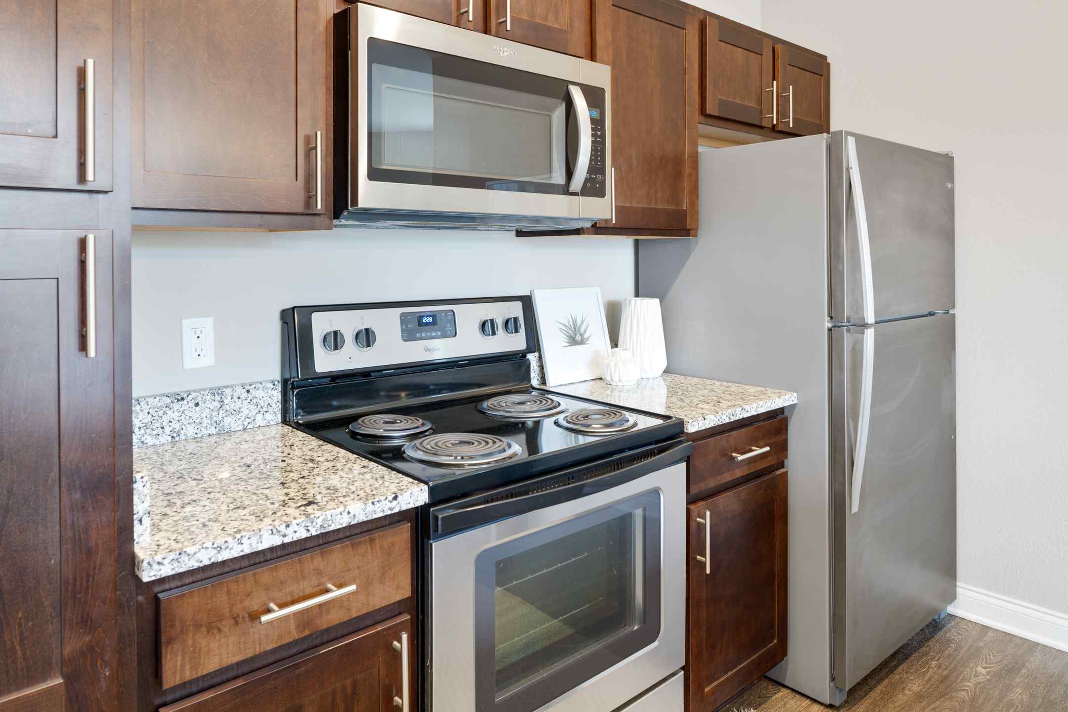 Newly renovated apartment kitchen equipped with modern appliances, including an oven, microwave, and refrigerator.