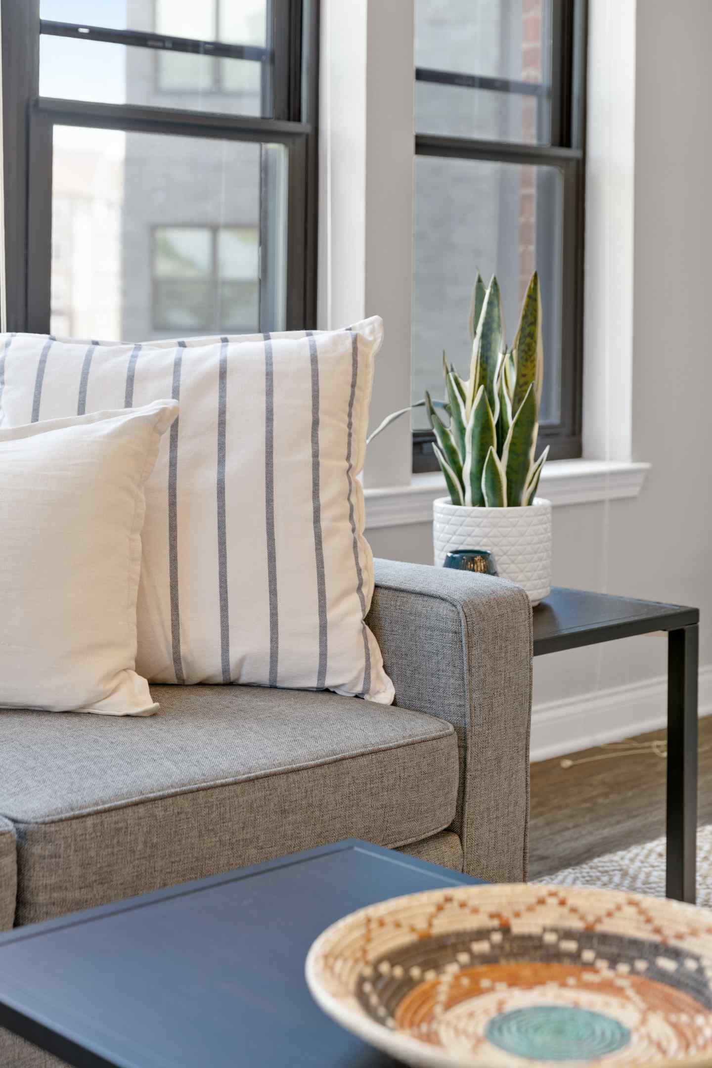 Cozy living room with a comfortable couch, stylish coffee table, and a large window letting in natural light.