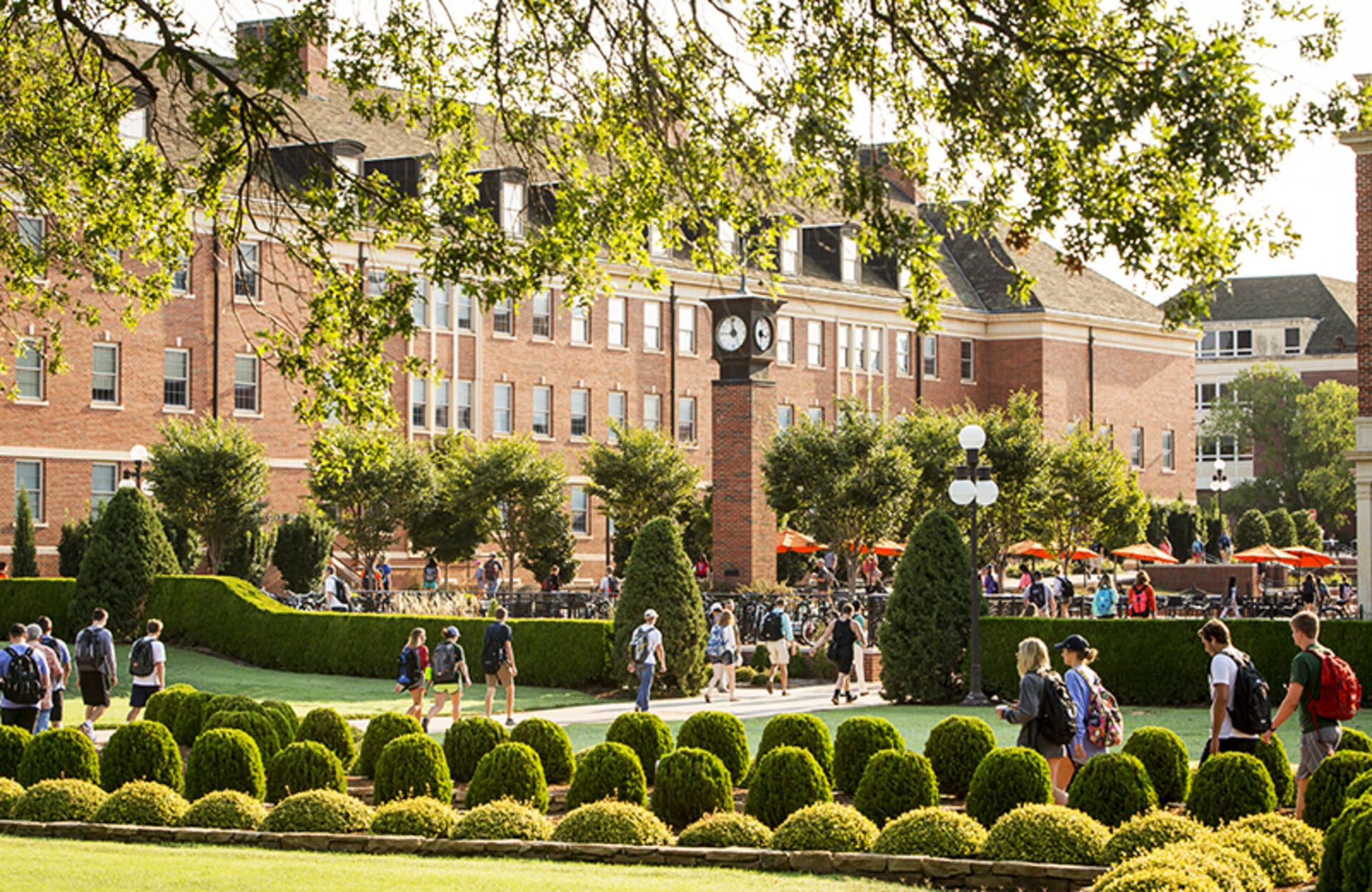 View of the beautiful OSU campus with lush green lawns, modern buildings, and students walking between classes.