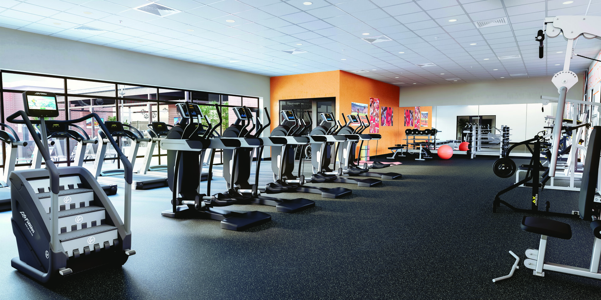 A well-equipped gym room with exercise equipment and mirrors in a student housing fitness center.